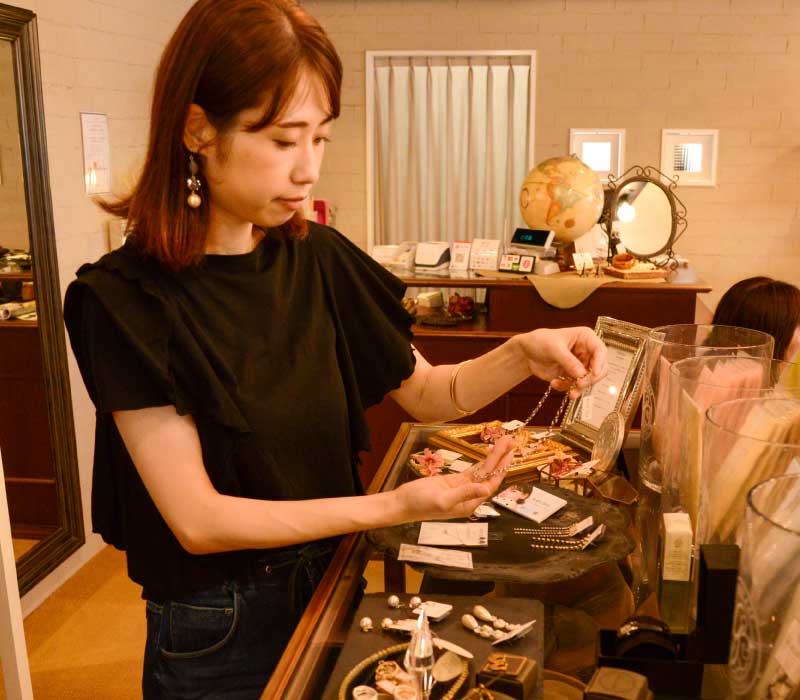 スタッフがラックの上のアクセサリーの商品の陳列する様子